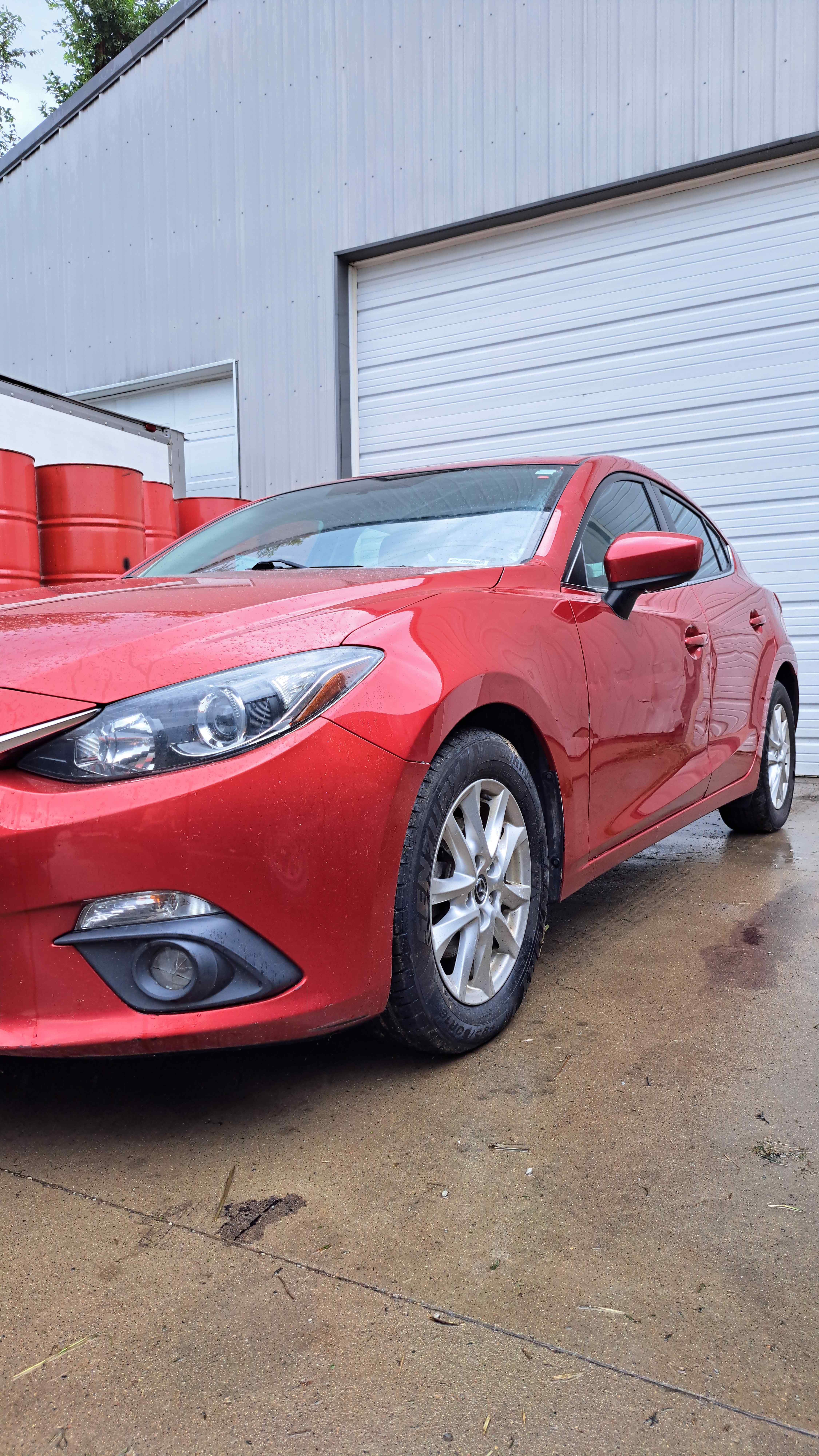 A freshly corrected red Mazda3 with a glossy, reflective finish